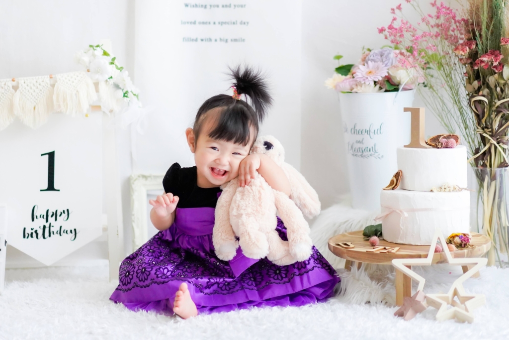 紫のドレスを着た1歳の女の子